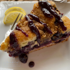 blueberry cake on a plate with lemon garnish