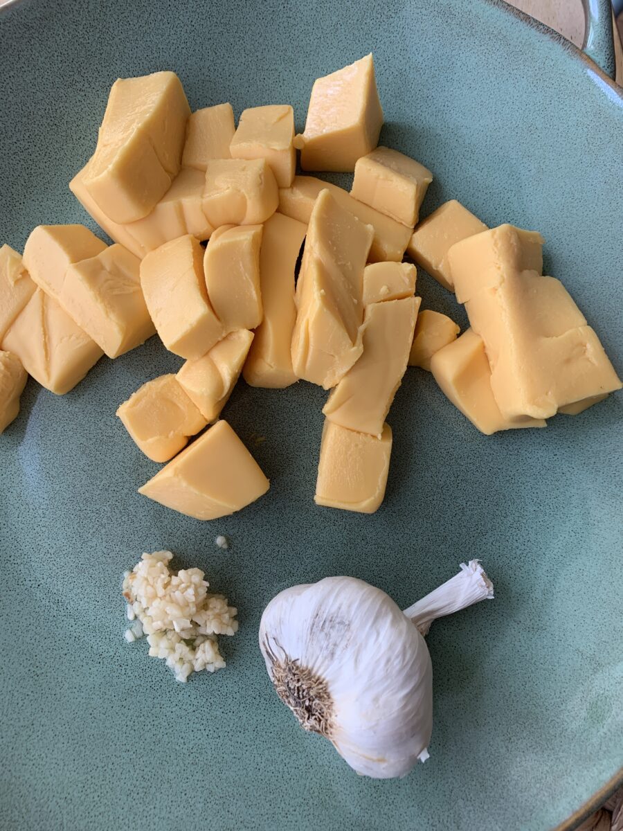 Cubed cheese and garlic on a plate.