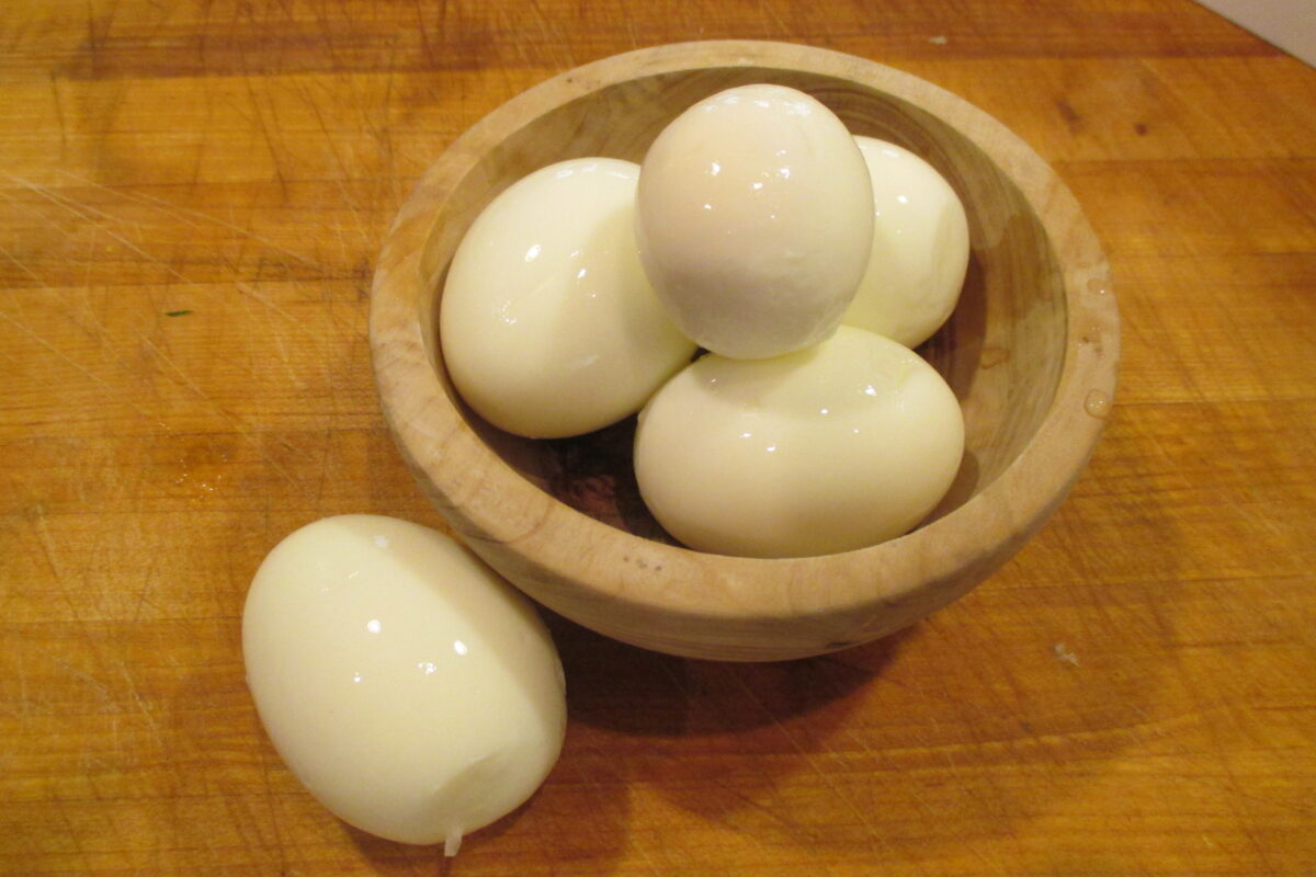 Hard boiled eggs in wooden bowl. 