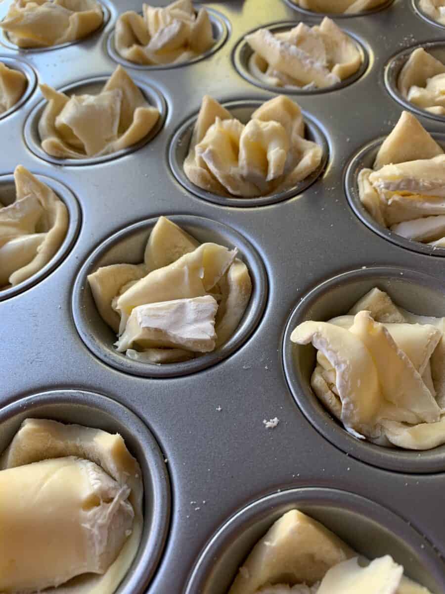 Brie and pastry dough in a mini muffin pan