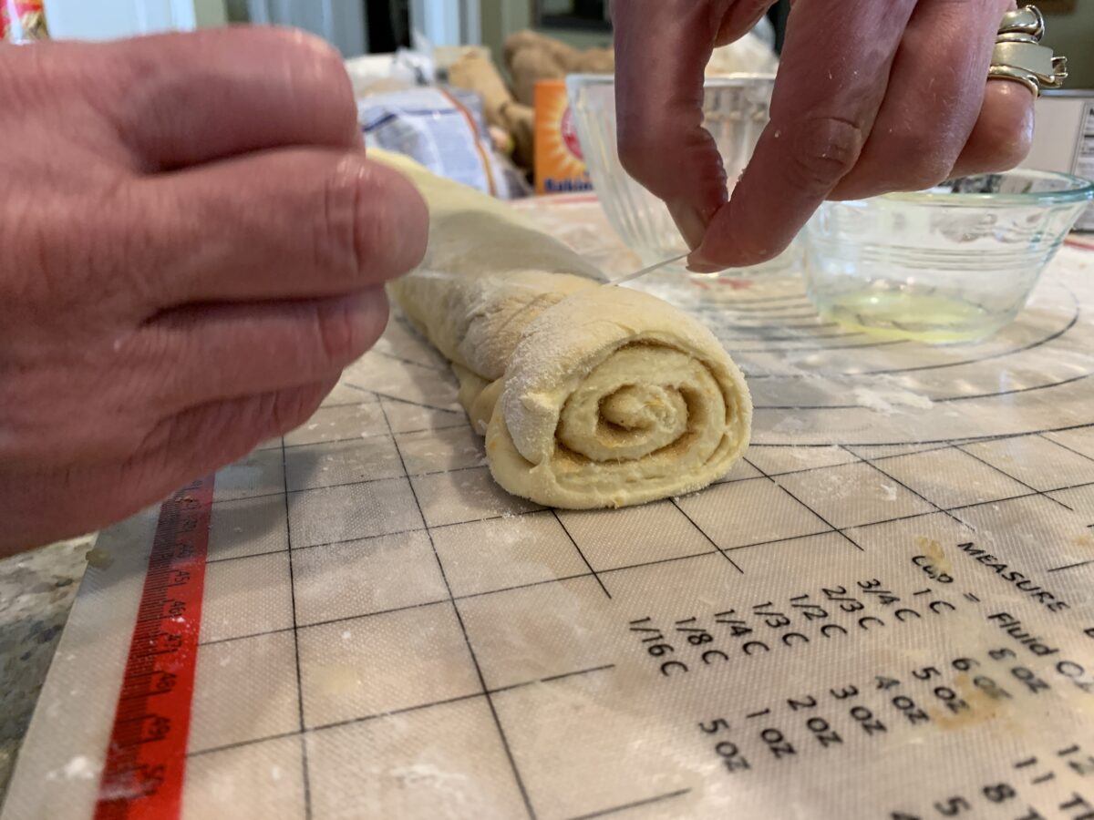 Sweet roll dough being sliced 