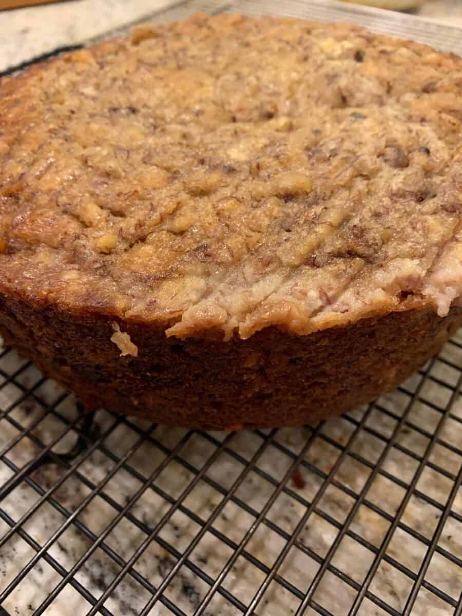 A round loaf of banana bread on a cooling rack.