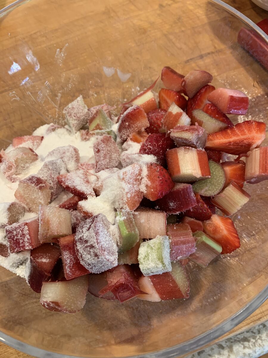 Diced strawberries and rhubarb in a bowl with sugar and flour. 