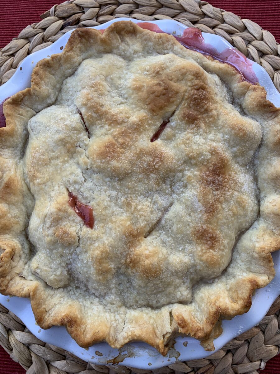 A baked strawberry rhubarb pie, out of the oven.
