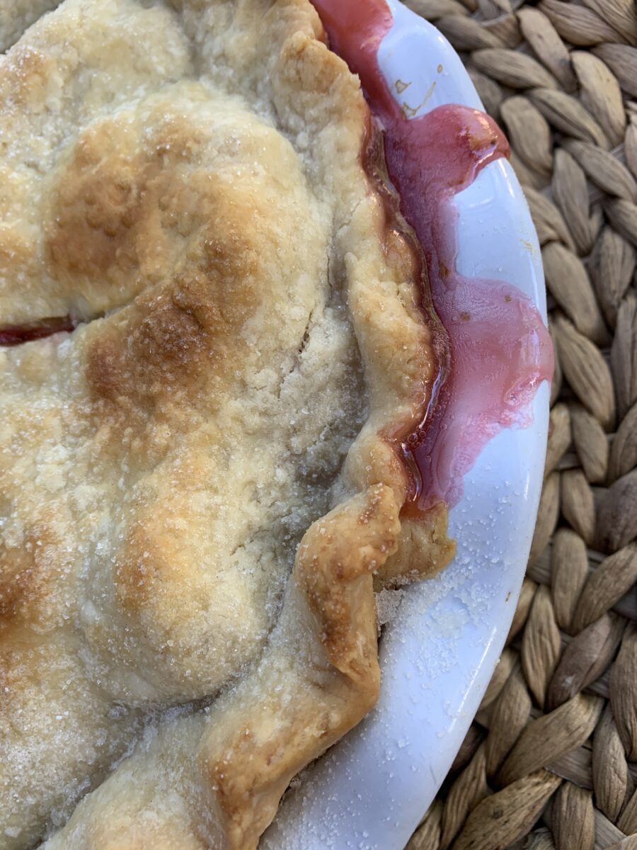 Tight shot of the filling bubbled from the strawberry rhubarb pie and the pie crust. 