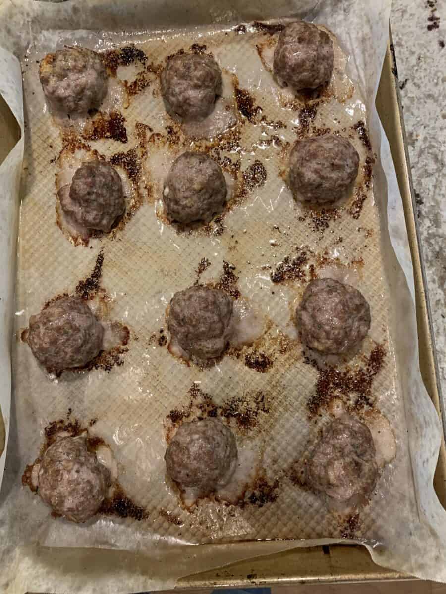 Twelve baked meatballs on a pan