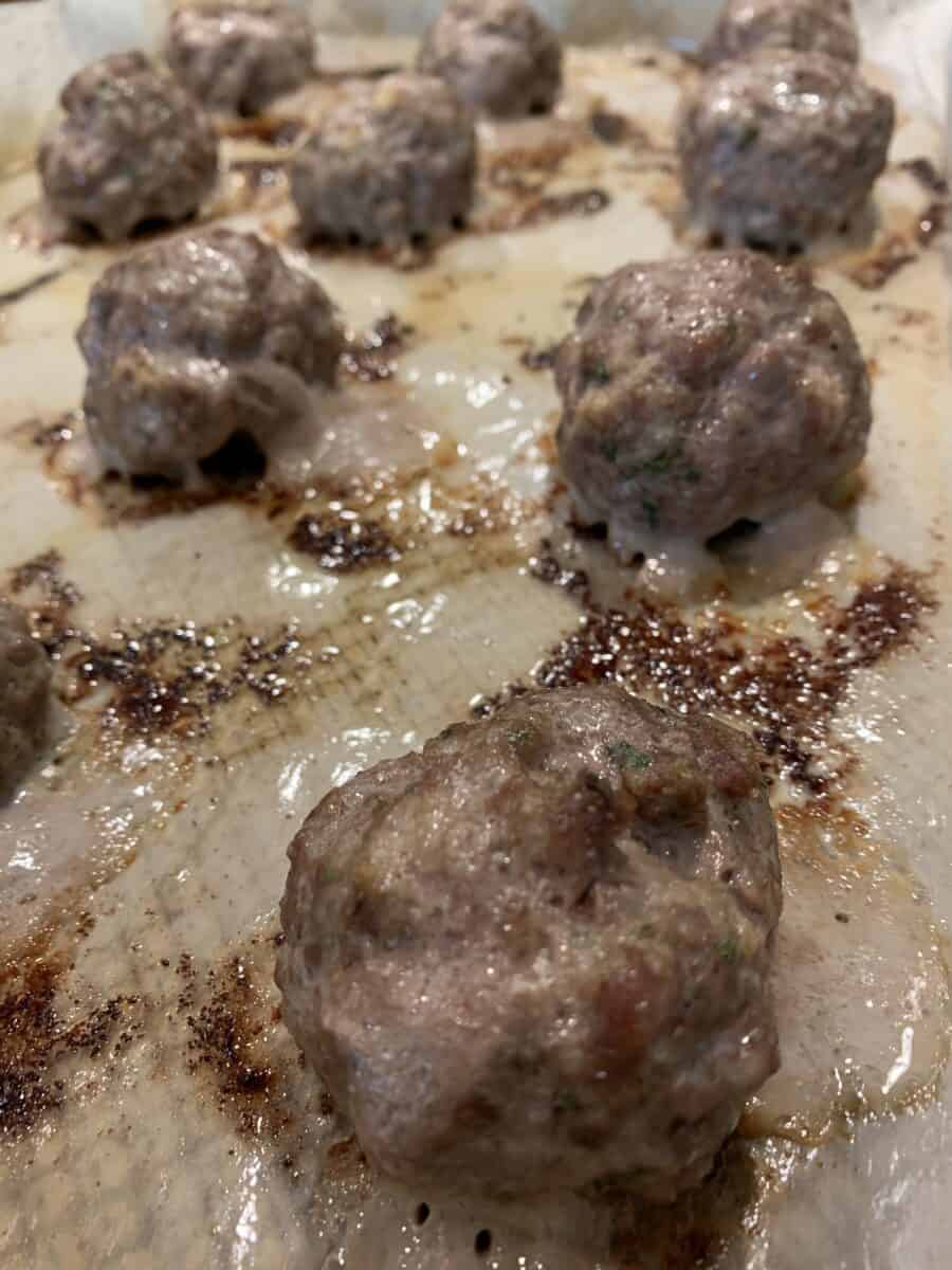 Cooked meatballs on a baking sheet. 