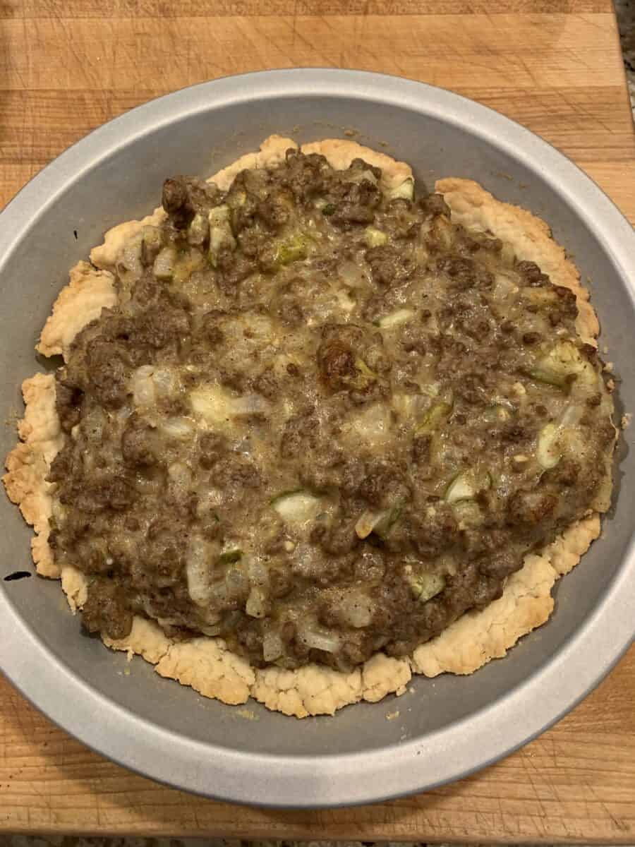 cheeseburger pie ingredients in a pie tin, before the cheese