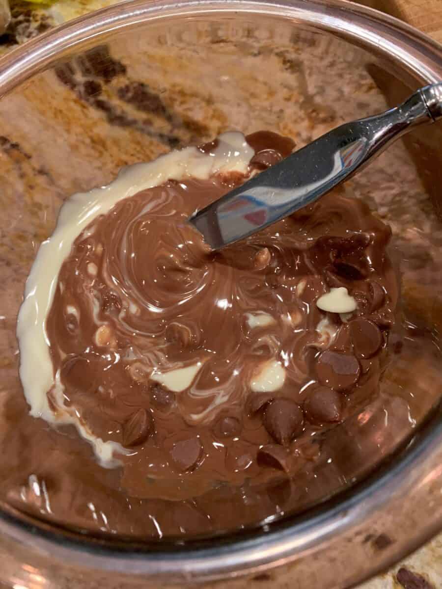 while chocolate and milk chocolate chips melted in a bowl