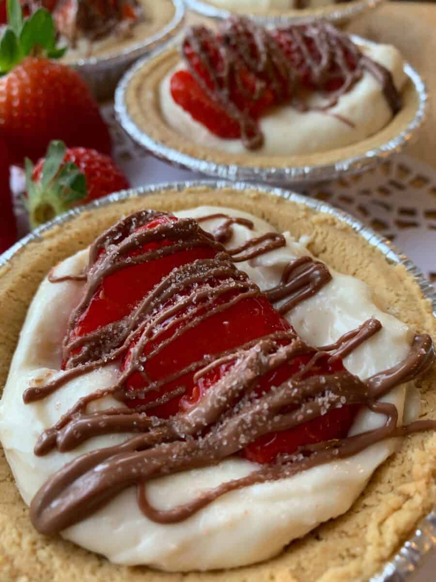 Chocolate strawberry pie with chocolate drizzled across the top of sliced berries.