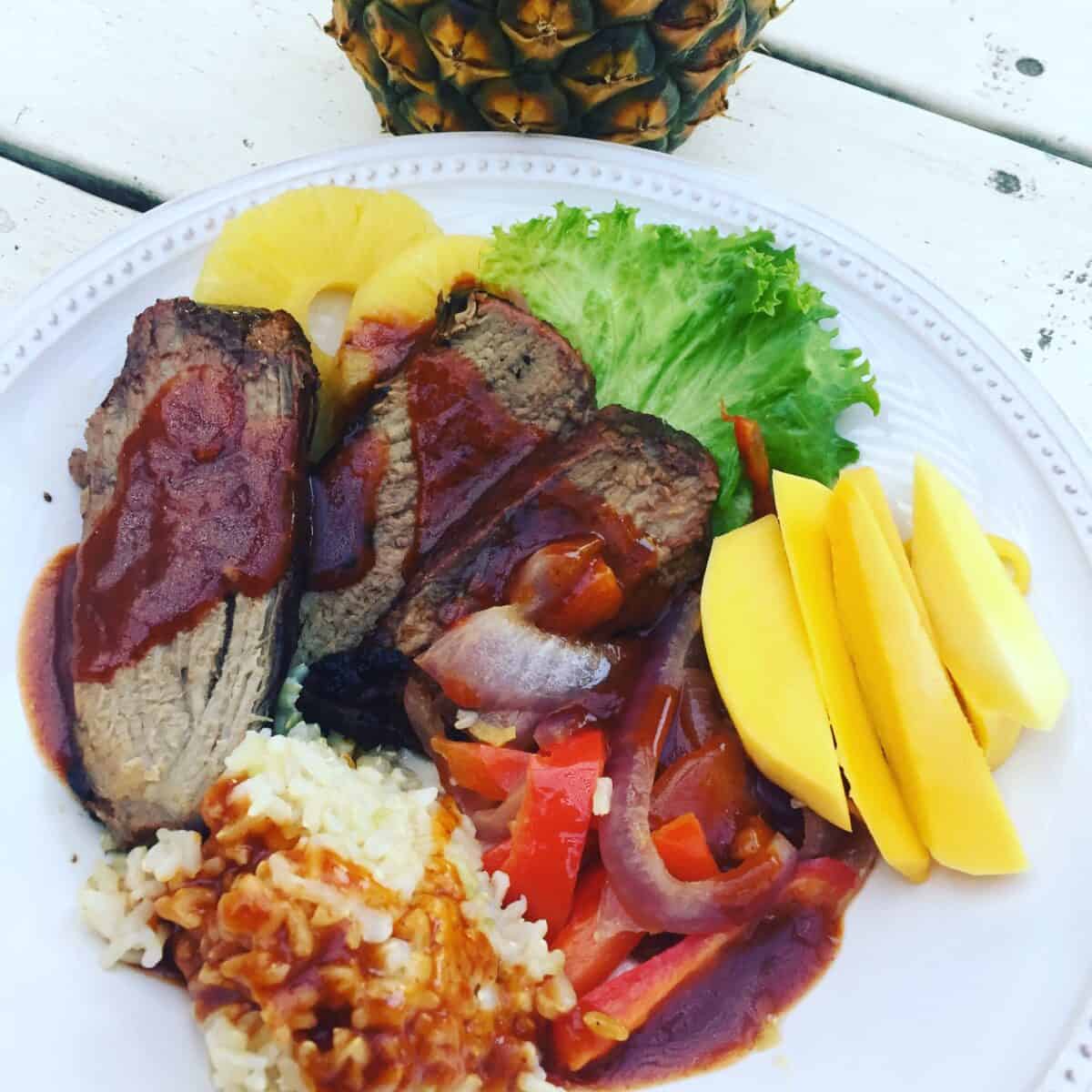 Idaho beef on a plate with rice, mango, red onion, red pepper, pineapple and lettuce.