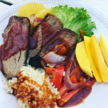 Idaho beef on a plate with rice, mango, red onion, red pepper, pineapple and lettuce.