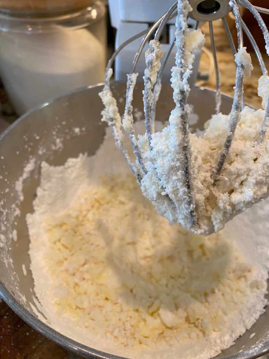 A mixing bowl and beaters with powdered sugar and butter, whipped together. 