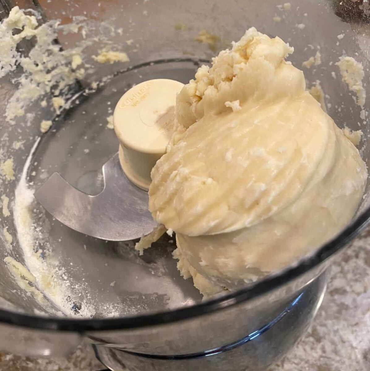 Small mound of unbaked shortbread dough in a food processor.