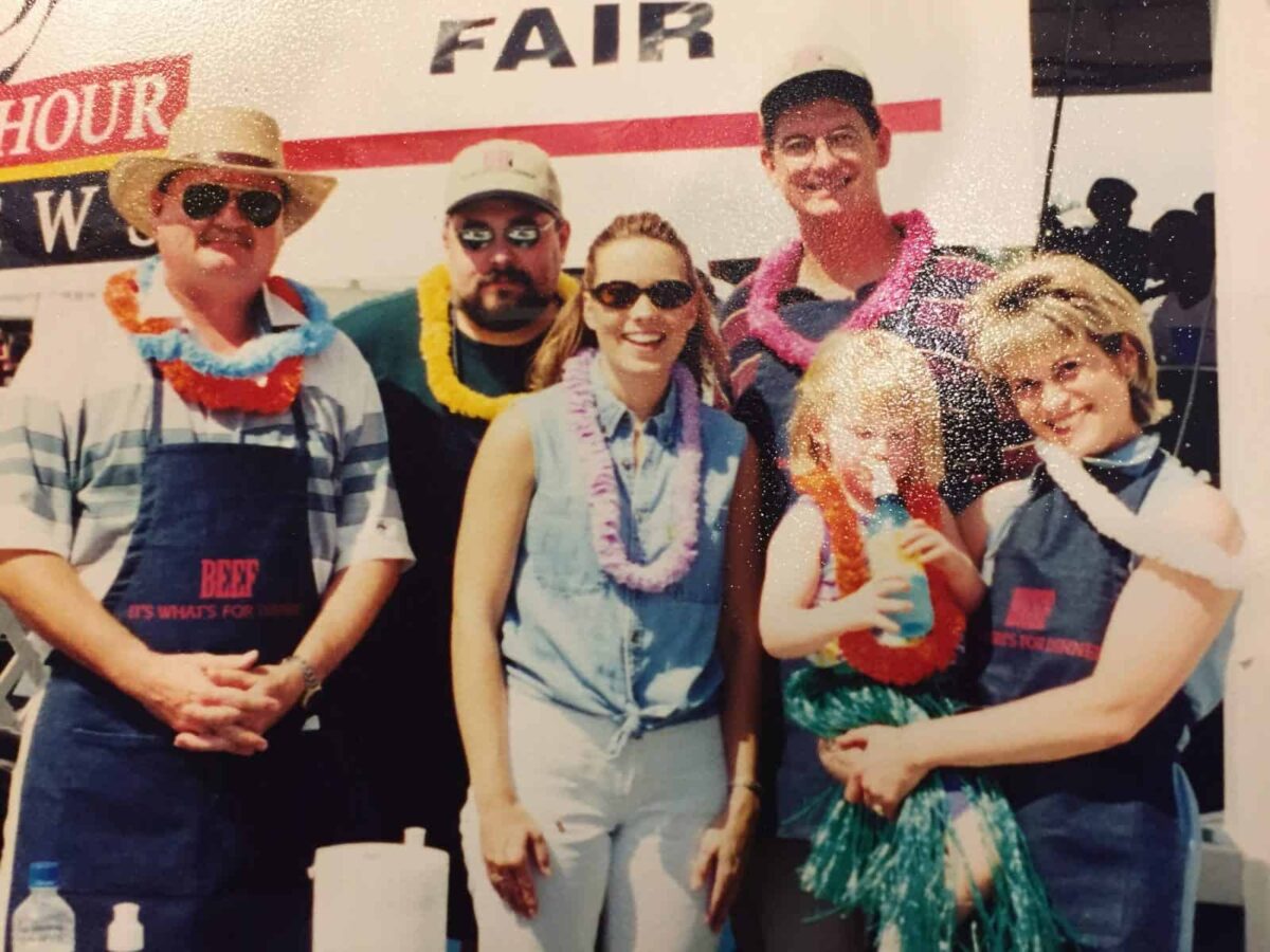 Six people in front of a banner at the Western Idaho Fair, 1999.