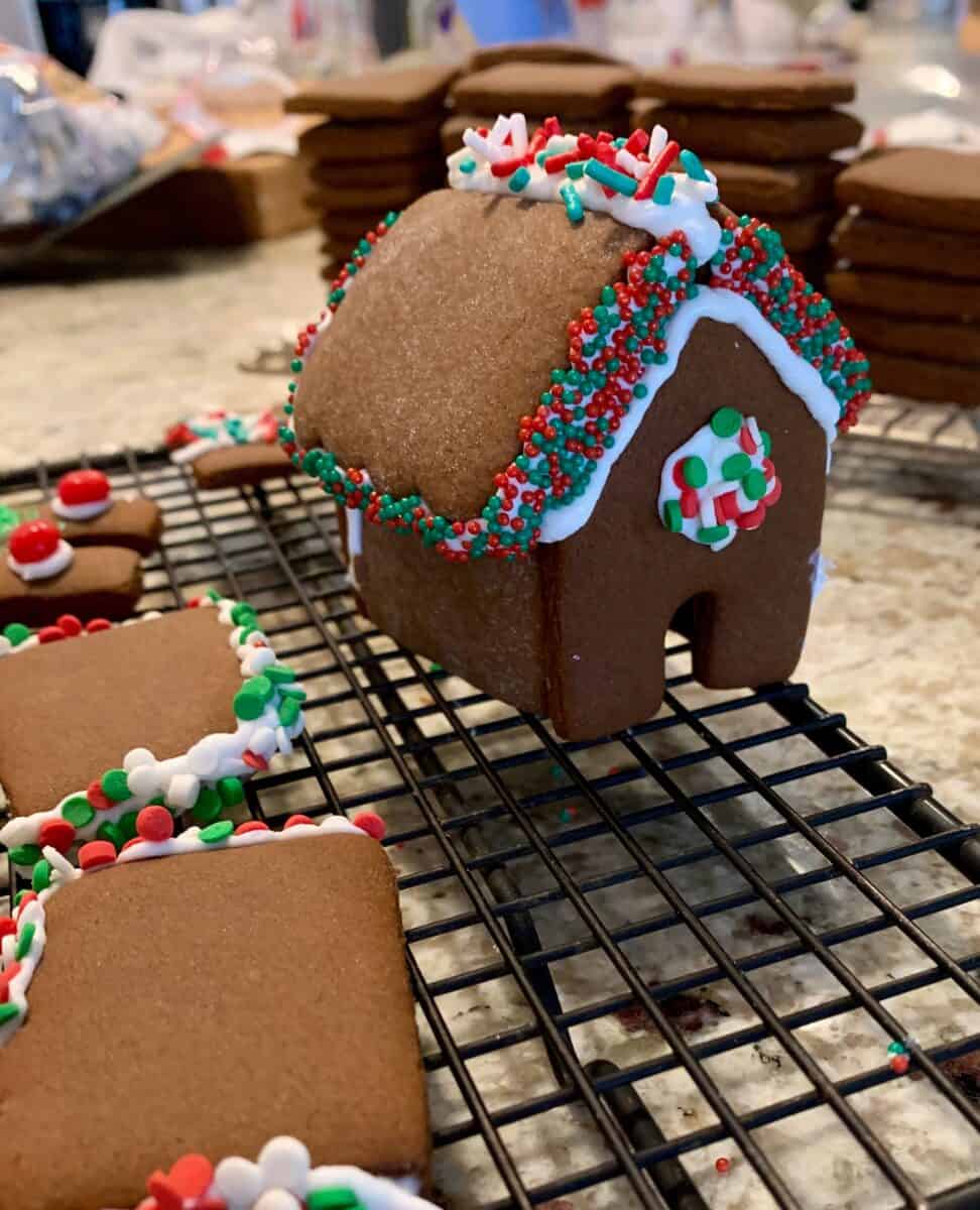 Mini-gingerbread house, decorated with icing, on a cooling rack