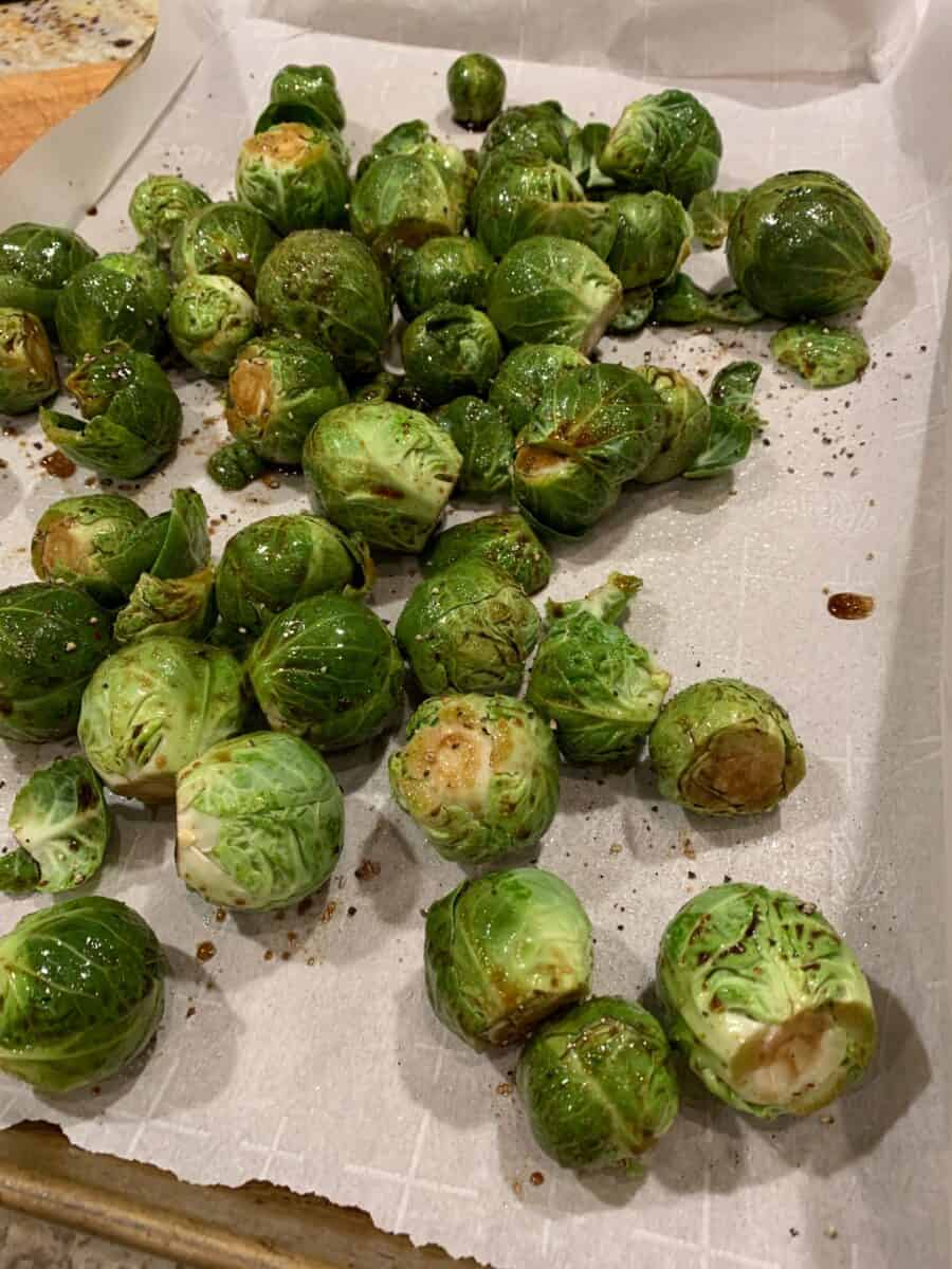 Veggies spread out on a baking sheet lined with parchment paper. 