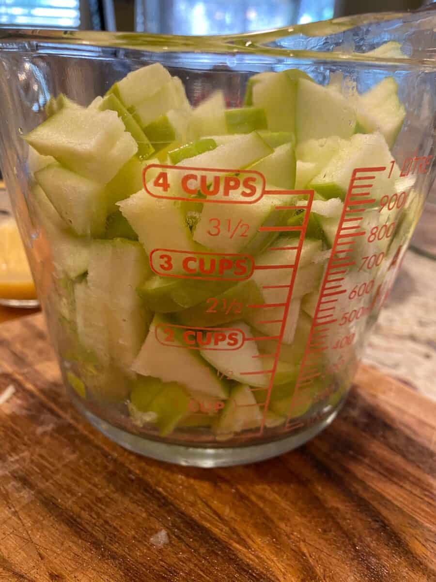 Diced apples in a glass measure cups.