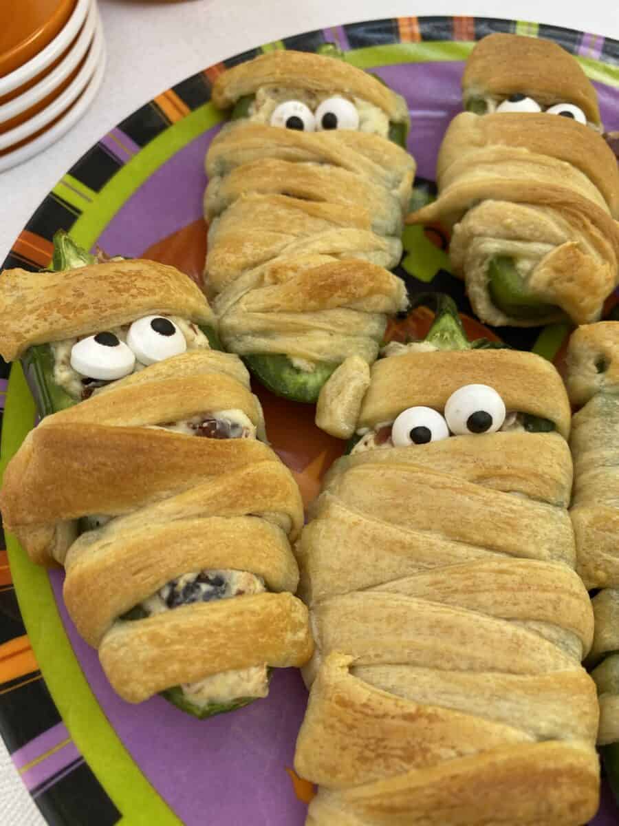 Jalapeno popper wrapped with dough and displaying candy eyes.