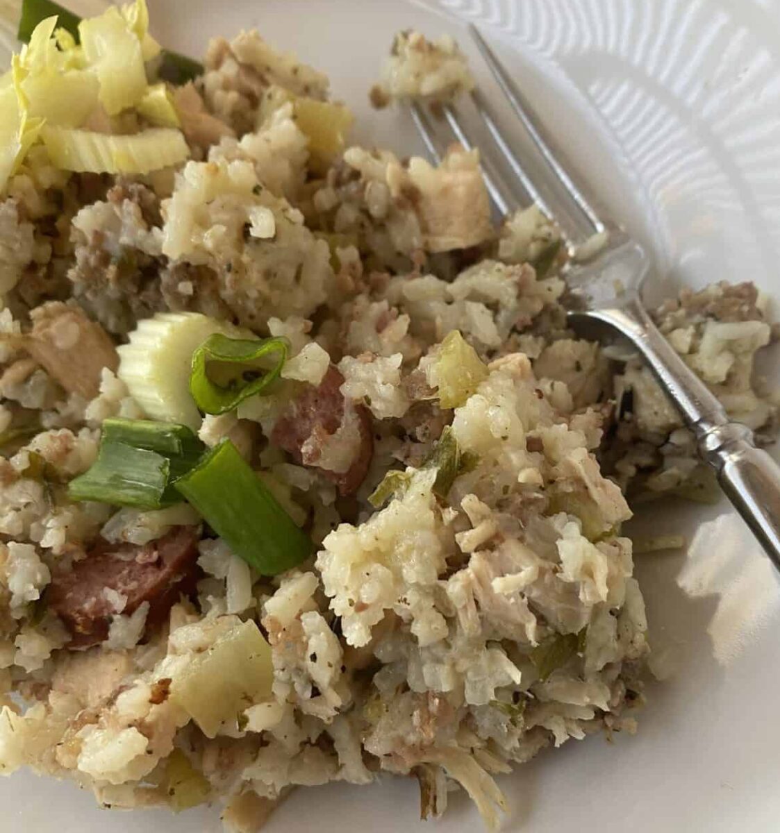 A scoop of jambalaya on a plate with a fork.