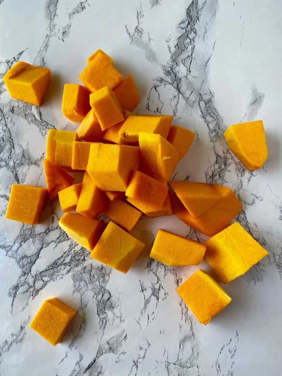 Diced butternut squash on a marble counter.