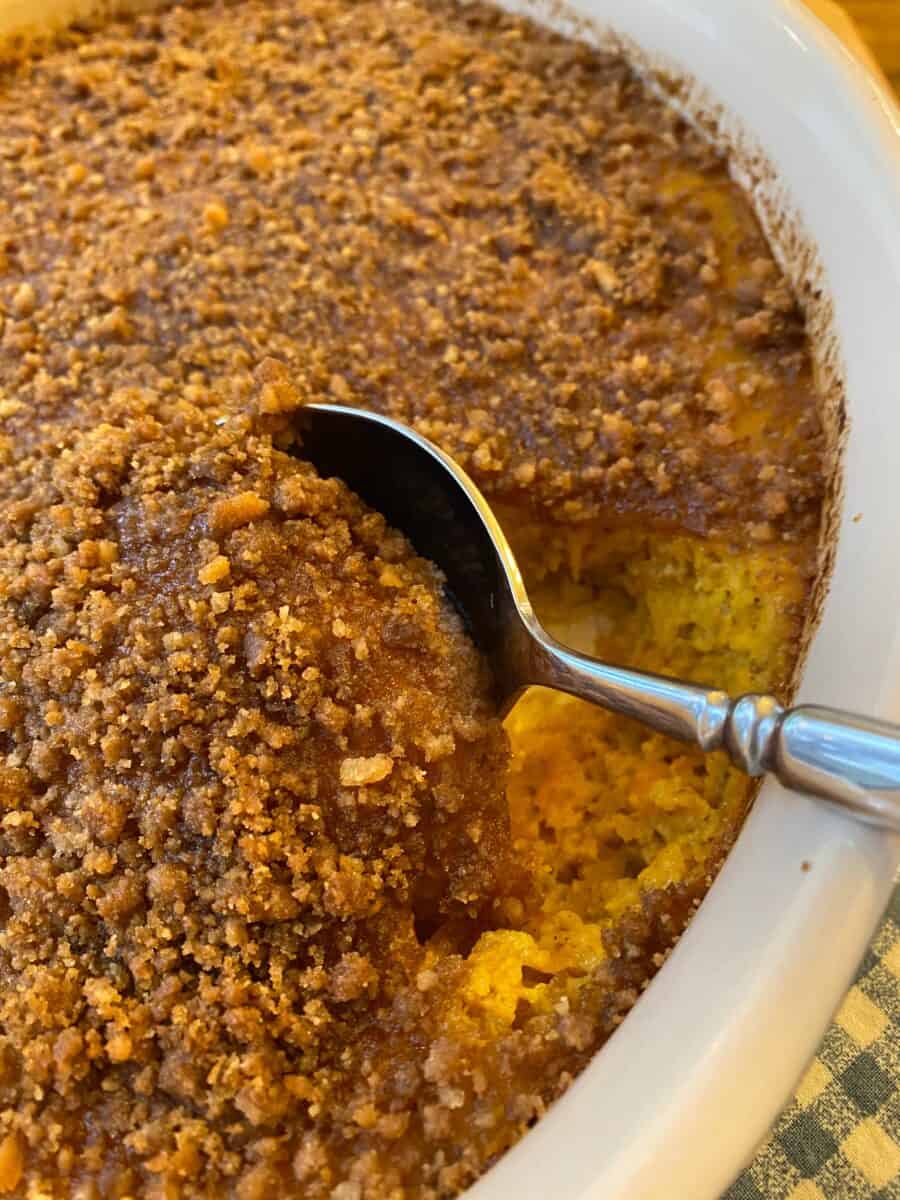 Baked cookie crumb casserole with a large serving spoon. 