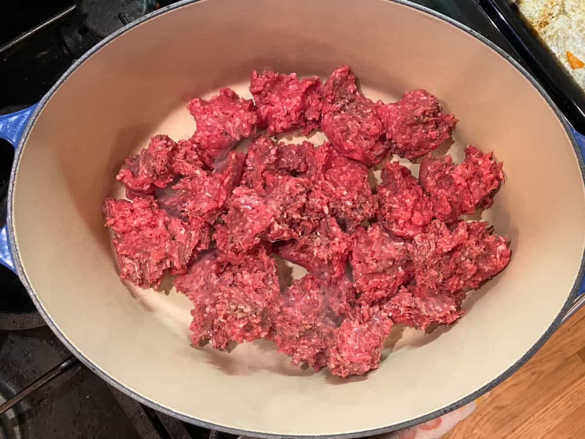 Uncooked ground beef in a large stockpot on the stove.