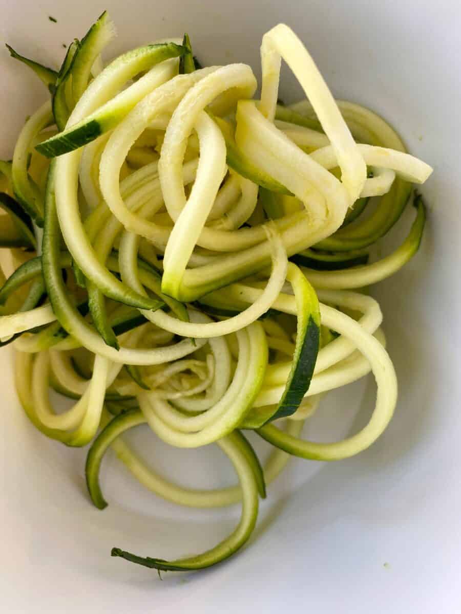 Curled zucchini noodles in a bowl.