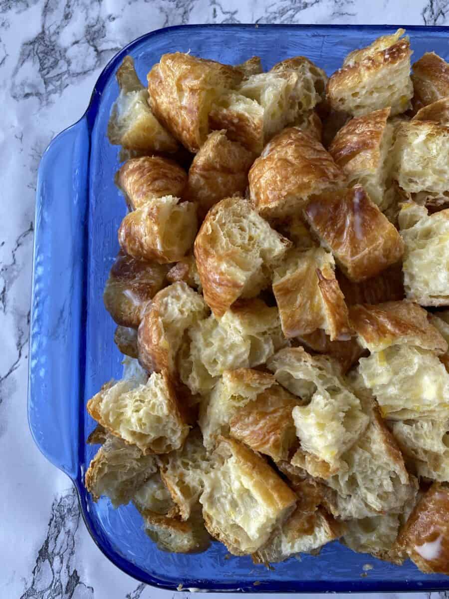 Diced croissants in a glass baking dish.