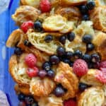 Croissant bread pudding with fruit in a baking dish, before baking.