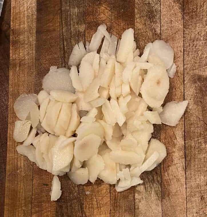 Diced water chestnuts on a cutting board.