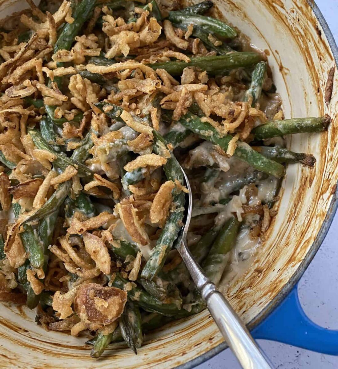 Baked green bean casserole with a serving spoon.