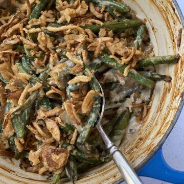 Baked green bean casserole with a serving spoon.