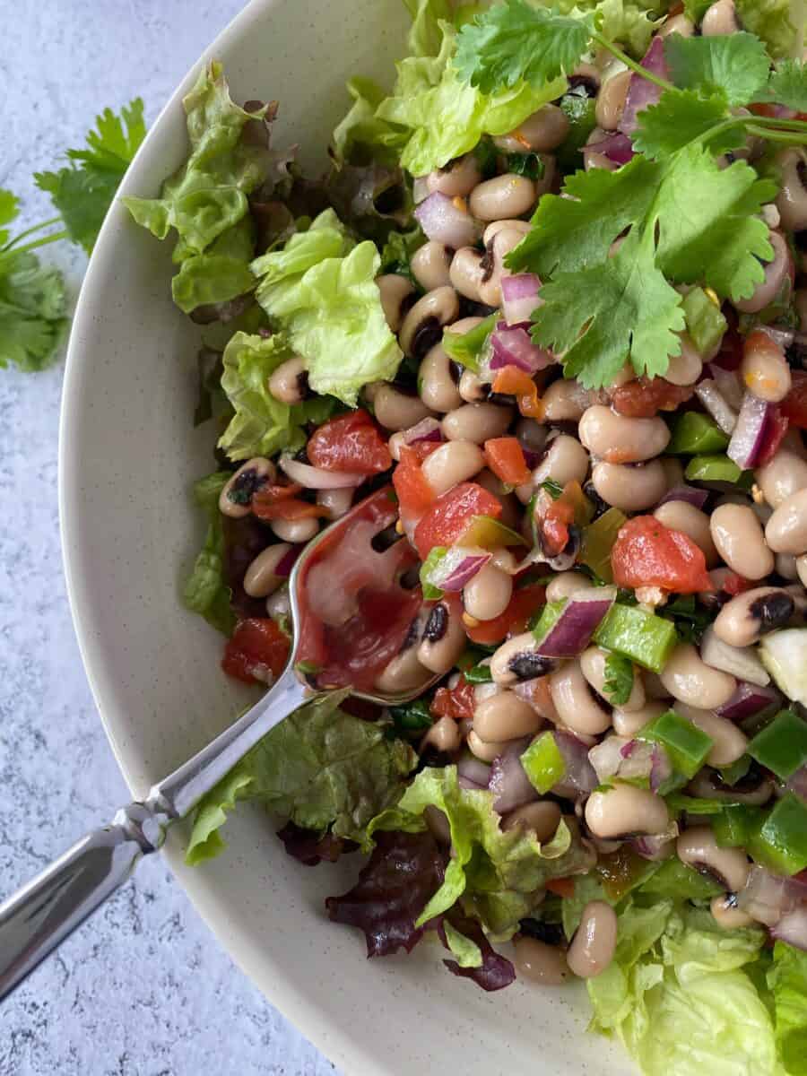 Black-eyed pea salad in a bowl with lettuce greens.