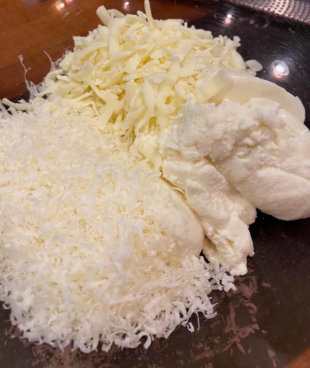 Mozzarella, parmesan and ricotta cheese in a large bowl.