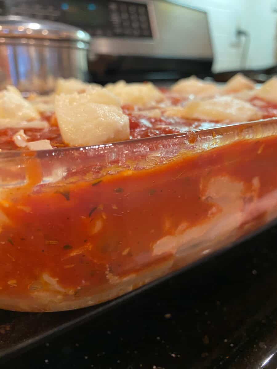 Cheesy Baked Ziti in a baking dish, on a stovetop. 