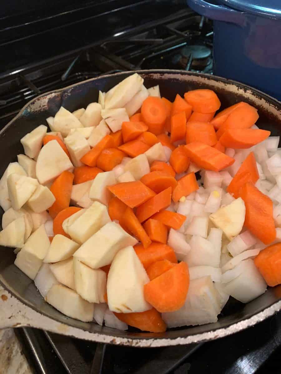 Parsnips, carrots and onion in a skillet. 