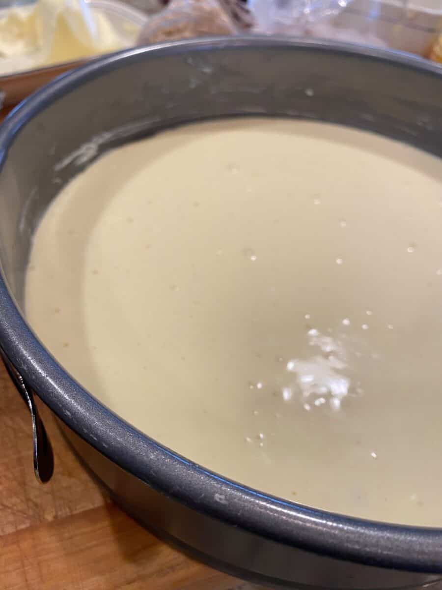 Raw cheesecake batter in a springform pan.