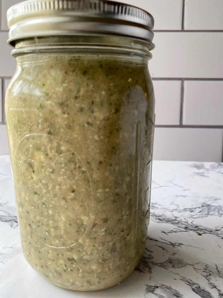 A glass jar full of salad dressing.