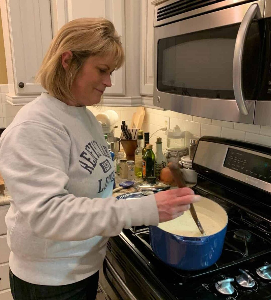 Melinda standing at the stove in the kitchen.