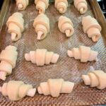 Unbaked potato rolls on a baking pan in the oven