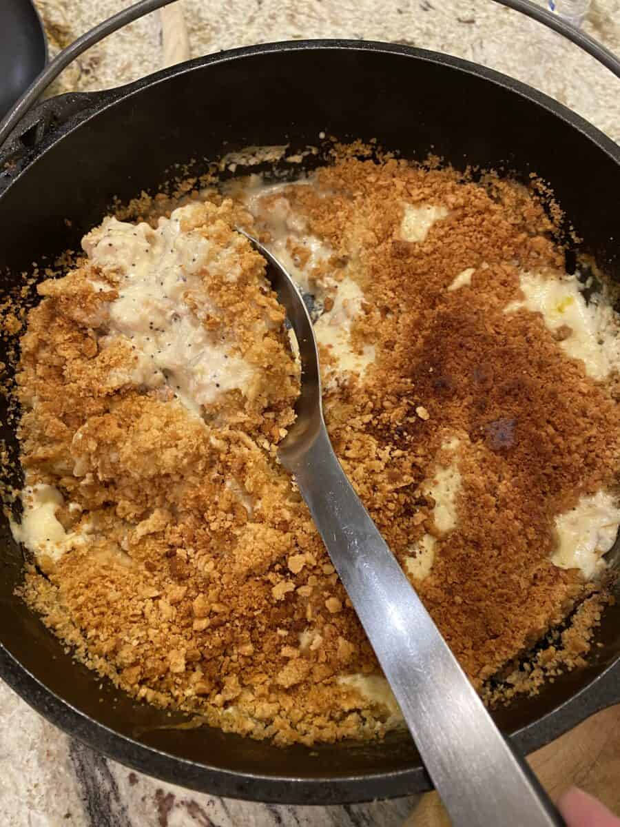 Chicken casserole with a large spoon in a Dutch Oven