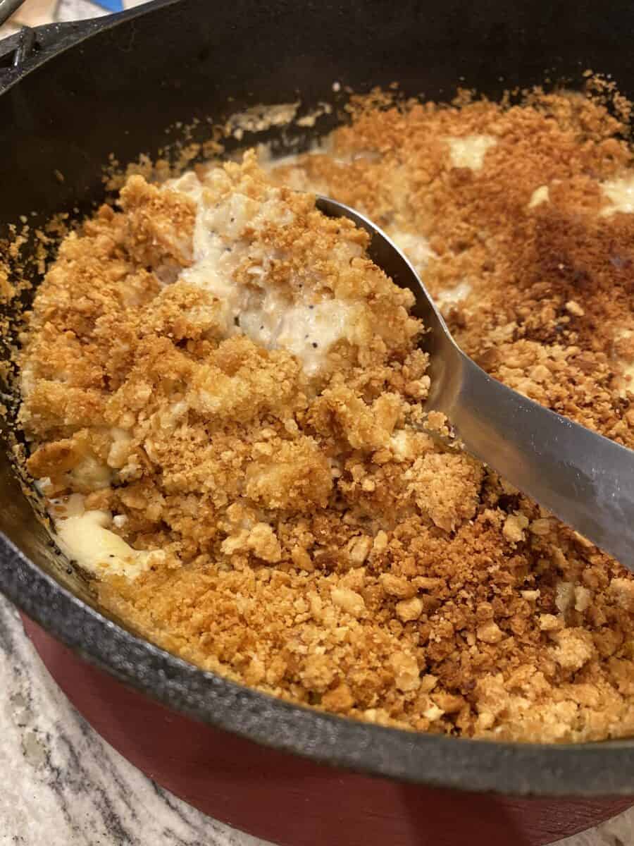 Cooked chicken casserole in a large Dutch Oven pot with a spoon.