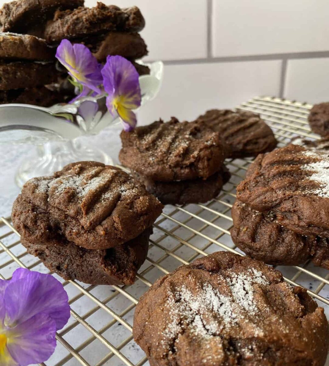 Snaps on a cooling rack with a pansy on the side.