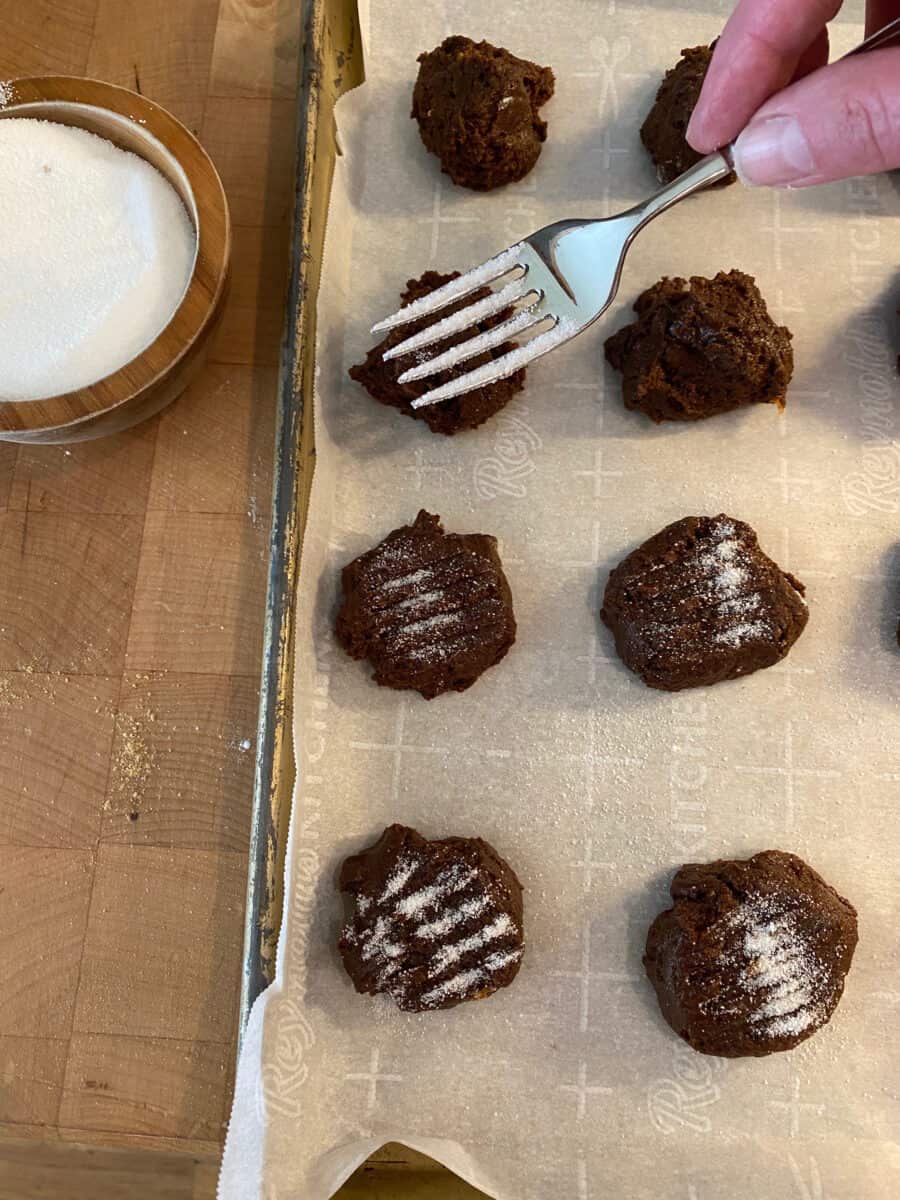 A fork with sugar over a baking pan of molasses snaps.