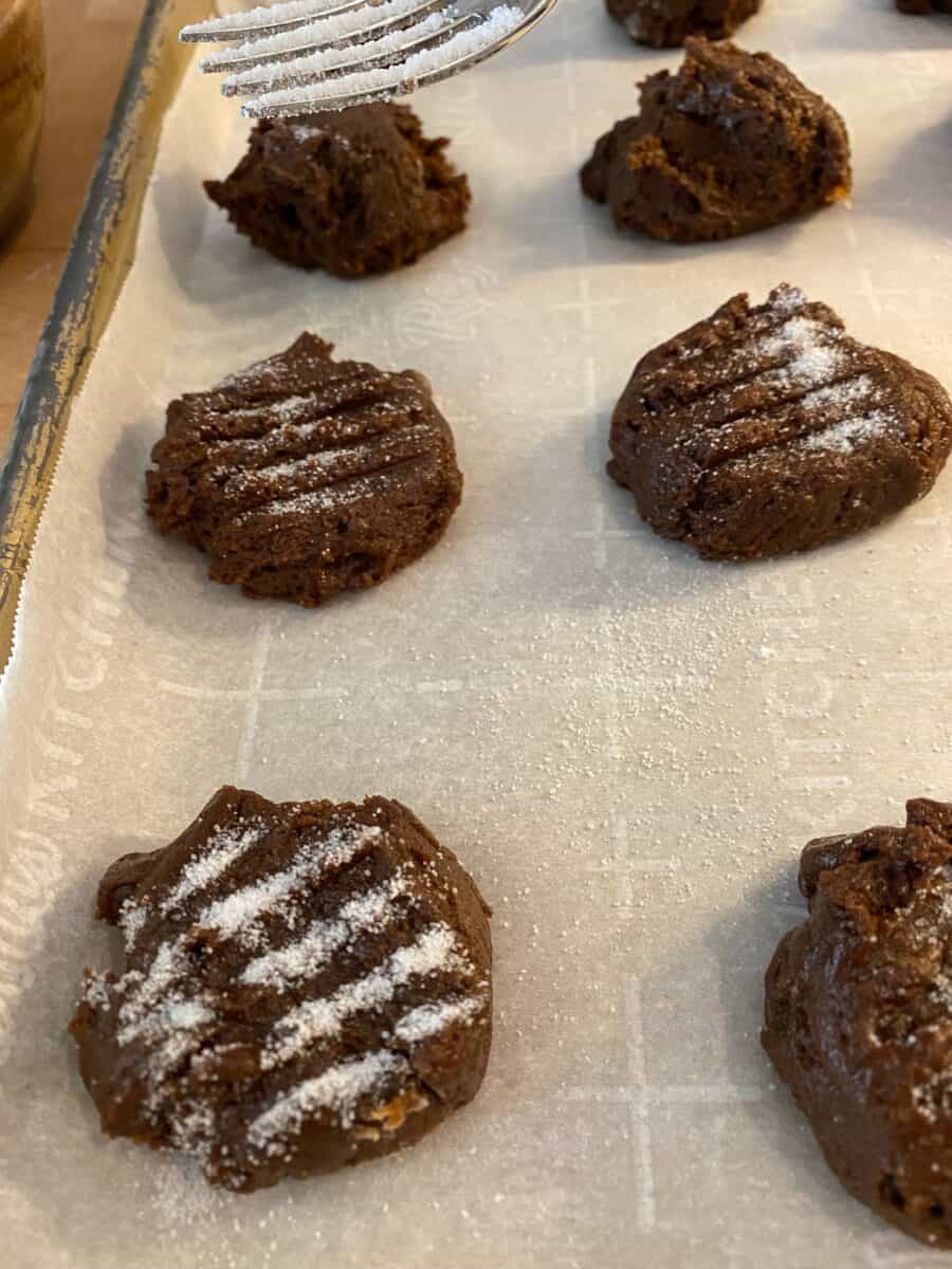 Molasses snaps on a baking pan with sugar sprinkled on top.