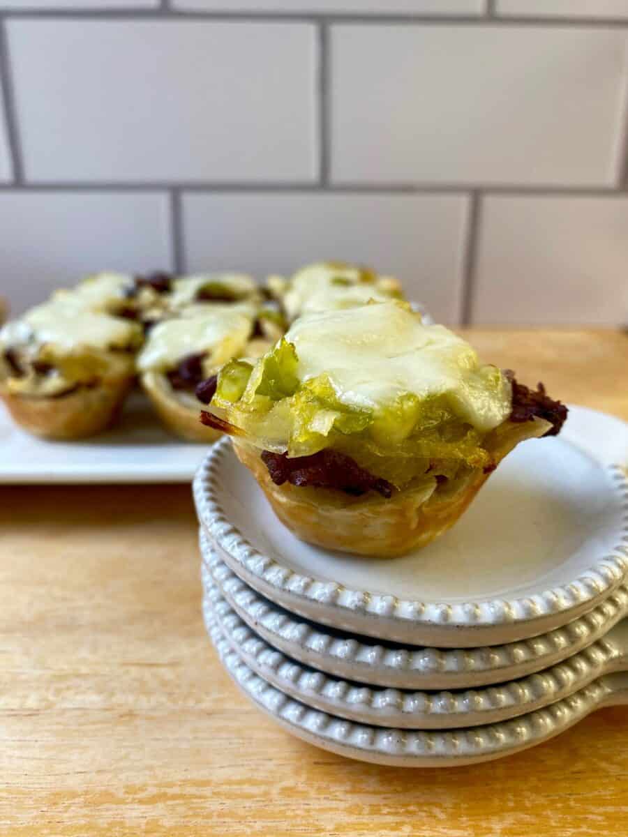 Philly Cheesesteak Bite on a small stack of dishes with the serving plate in the background.