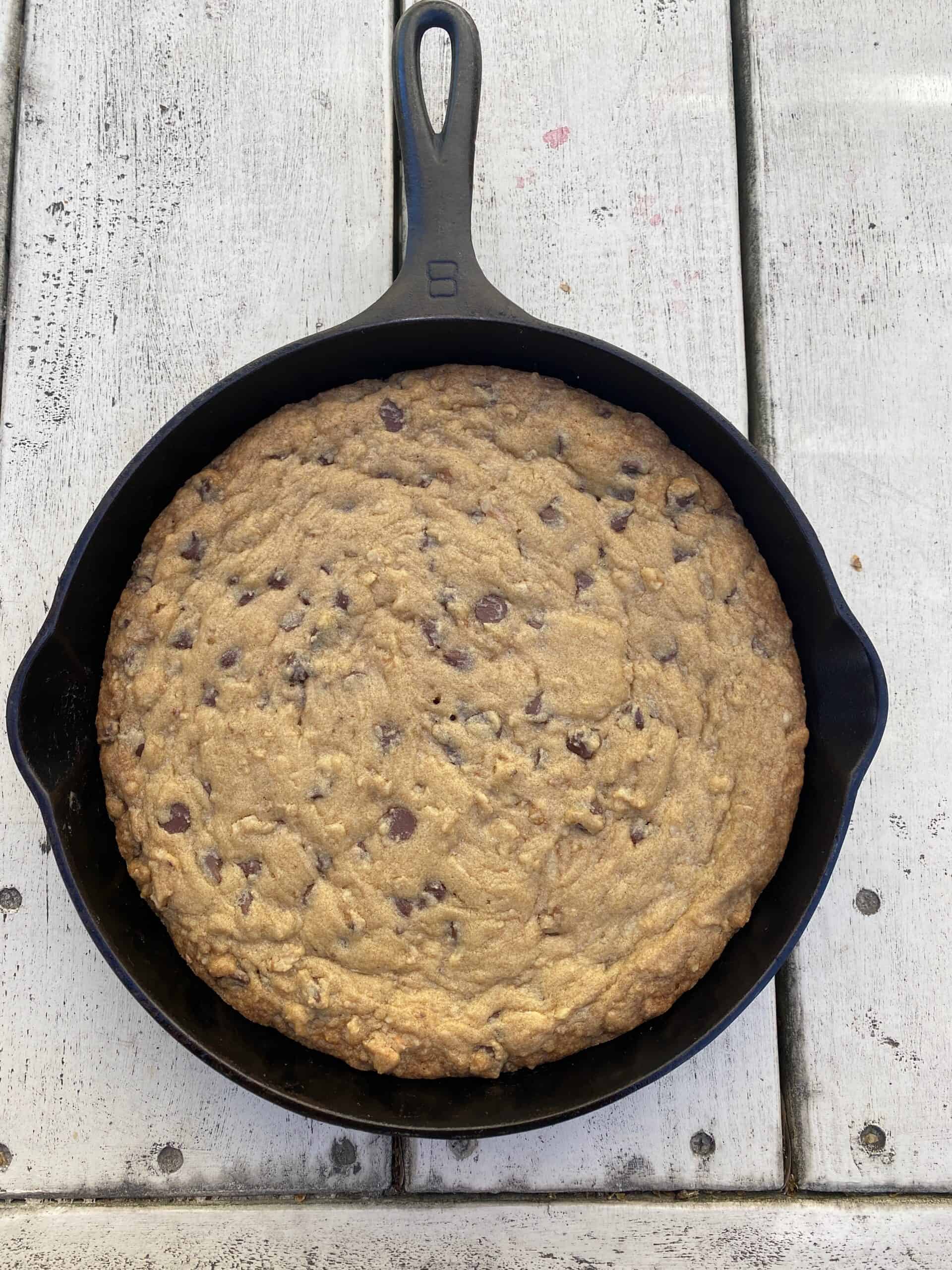 Baked Mrs Fields Chocolate Bars in a cast iron skillet on a wooden table.