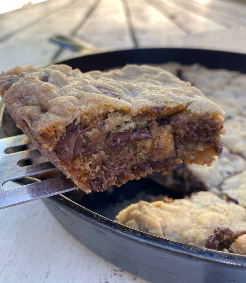 Bar cookie on a spatula lifted from a cast iron skillet.