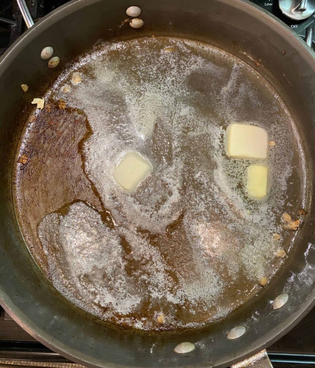 Butter melting in a hot skillet on the stove.